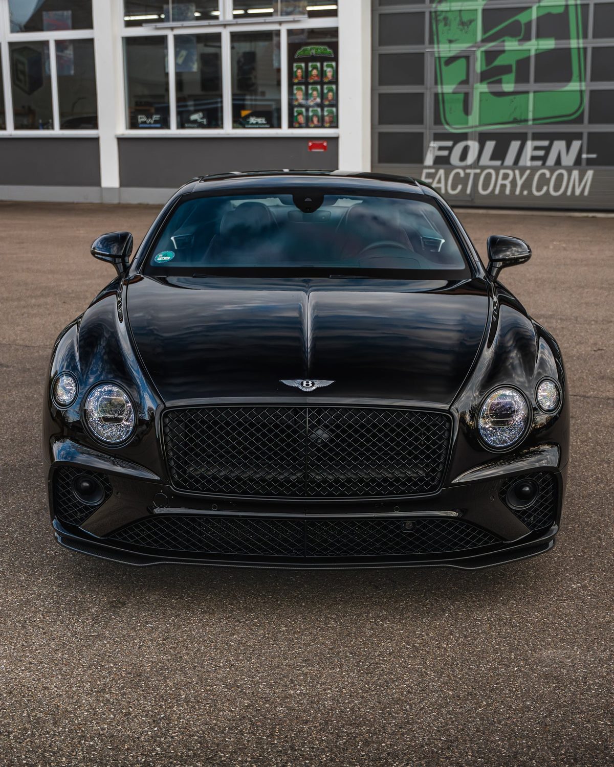 Front des schwarzen Bentley Continental GT mit Spiegelung in der Motorhaube
