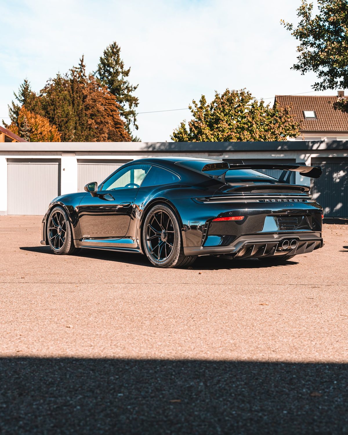 Schwarzer Porsche 992 GT3 von hinten auf dem Hof der Folien-Factory